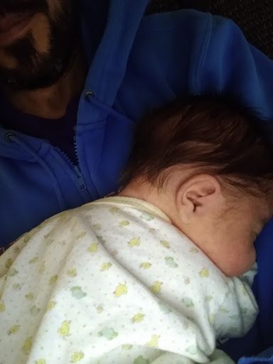 Baby resting on his dad's lap